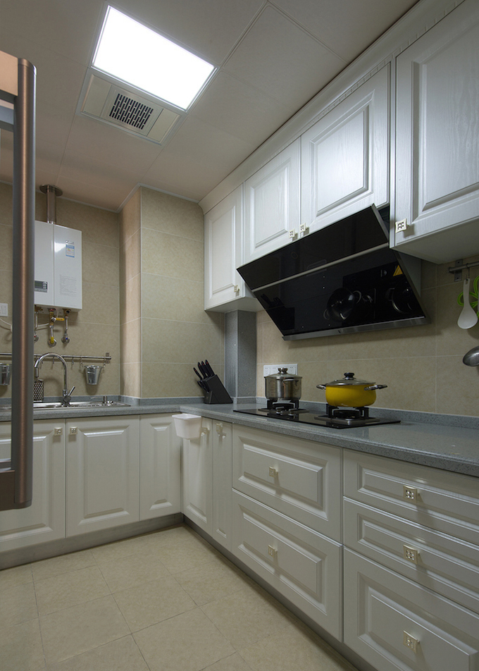 L型的厨房以深浅两种不同的白色配上台面的灰蓝，显得也十分的整洁。