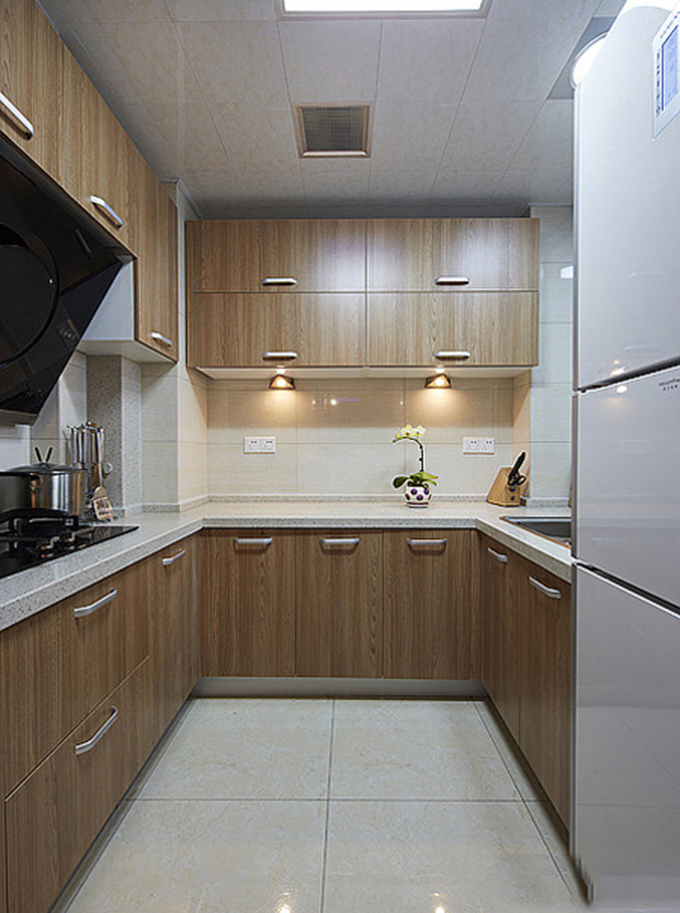 U型的厨房以实木橱柜配上白色的瓷砖，看起来非常整洁明亮，没有多余的色彩装饰。