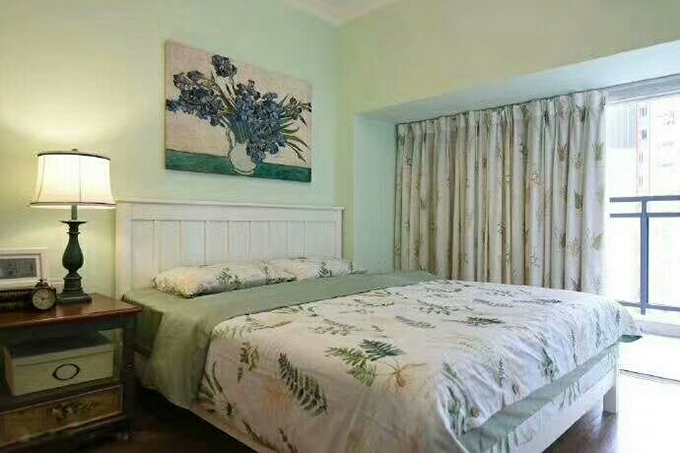 卧室整体都以浅绿色为背景，看起来也十分的清新舒适，挂画的搭配也窗帘及床上用品互相呼应，非常的一致。