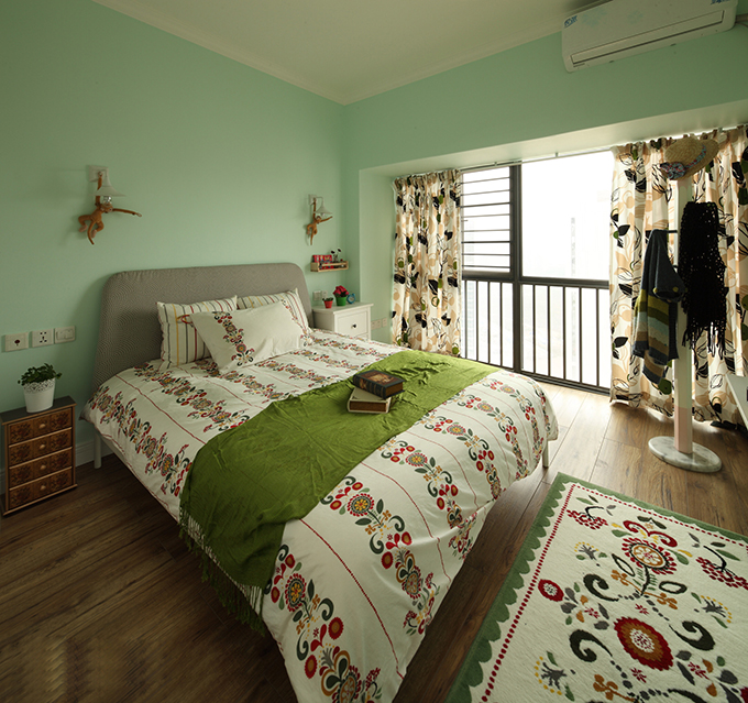 白色天花板与青色的墙面配搭体现出小清新的卧室，木制家具存托空间大自然，花式床上用品一地毯一致增加空间色彩。