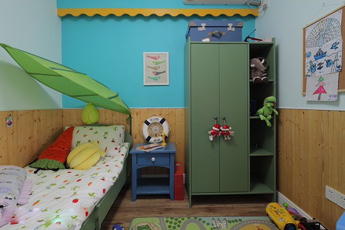 上墙使用蓝色对应着下墙木板体现塑造空间淳朴，树叶枝条对应着绿色双开柜突出空间色彩，赛车跑道地毯体现孩子纯真。