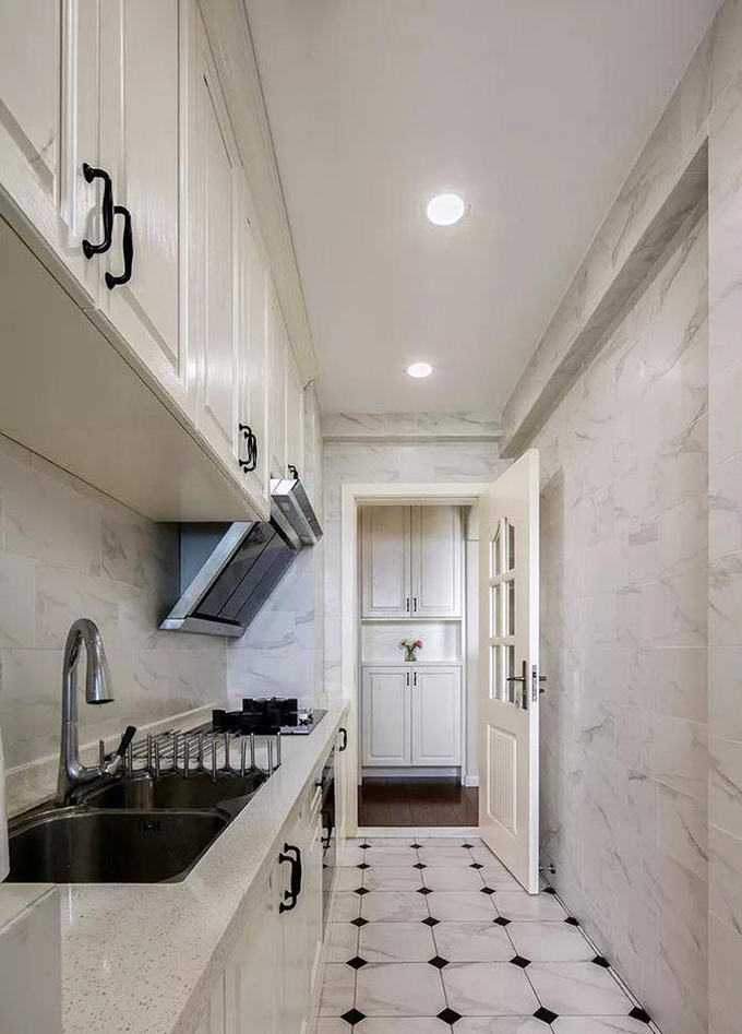 厨房狭长的空间以浅色的瓷砖来提亮空间，而且看上去也不会显得拥挤，再加上金属与瓷砖的搭配，也更加方便于打理。
