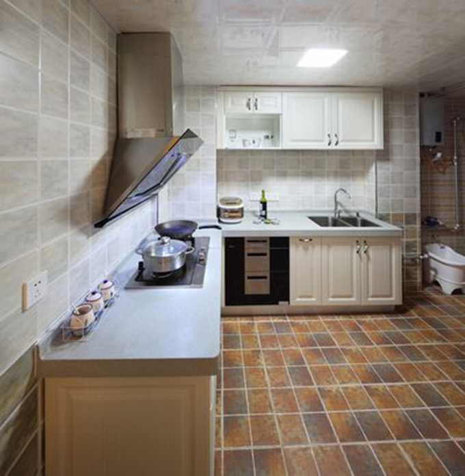使用L型厨房，花式小式瓷砖地面与灰色壁面瓷砖塑造空间温暖，白色橱柜与灰色灶台配搭点缀空间色彩淡雅。