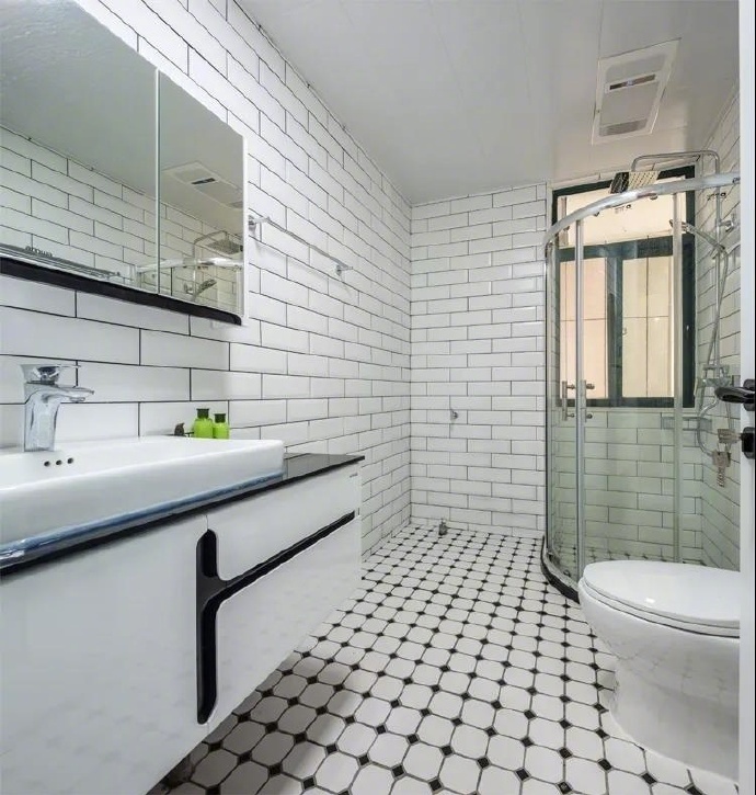 浴室的设计和厨房的设计一样，同样采用小方瓷砖，来达到空间的扩大化的作用，这种白色的瓷砖很容易将家里的卫生间装成公厕的感觉，但是这里的地面做了很好的瓷砖美缝，在瓷砖和瓷砖之间做了一个小小的拼贴，是整体风格变得现代化。