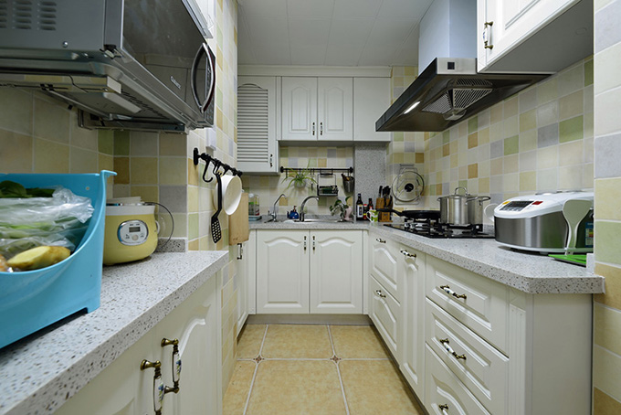 U字型的厨房以彩色小方格来装饰，再加上斑点的台面与耐脏的地方，非常符合地中海风格的感觉，布局也很方便操作。