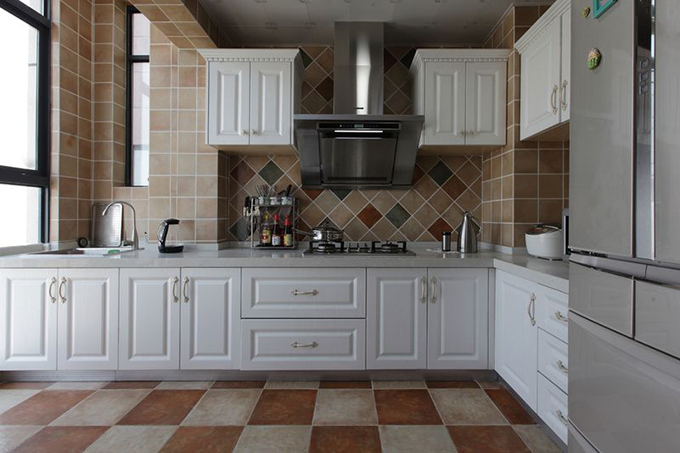 白色橱柜配置灰色灶面点缀厨房整洁干净，浅色和深色的瓷砖结合做成地面打造艺术之美，背景墙上添加几块瓷砖给空间增色彩。