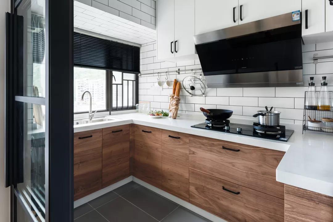 厨房，白色工字砖的墙面基础，搭配木质橱柜与黑色把手，整体轻松明亮又自然。
