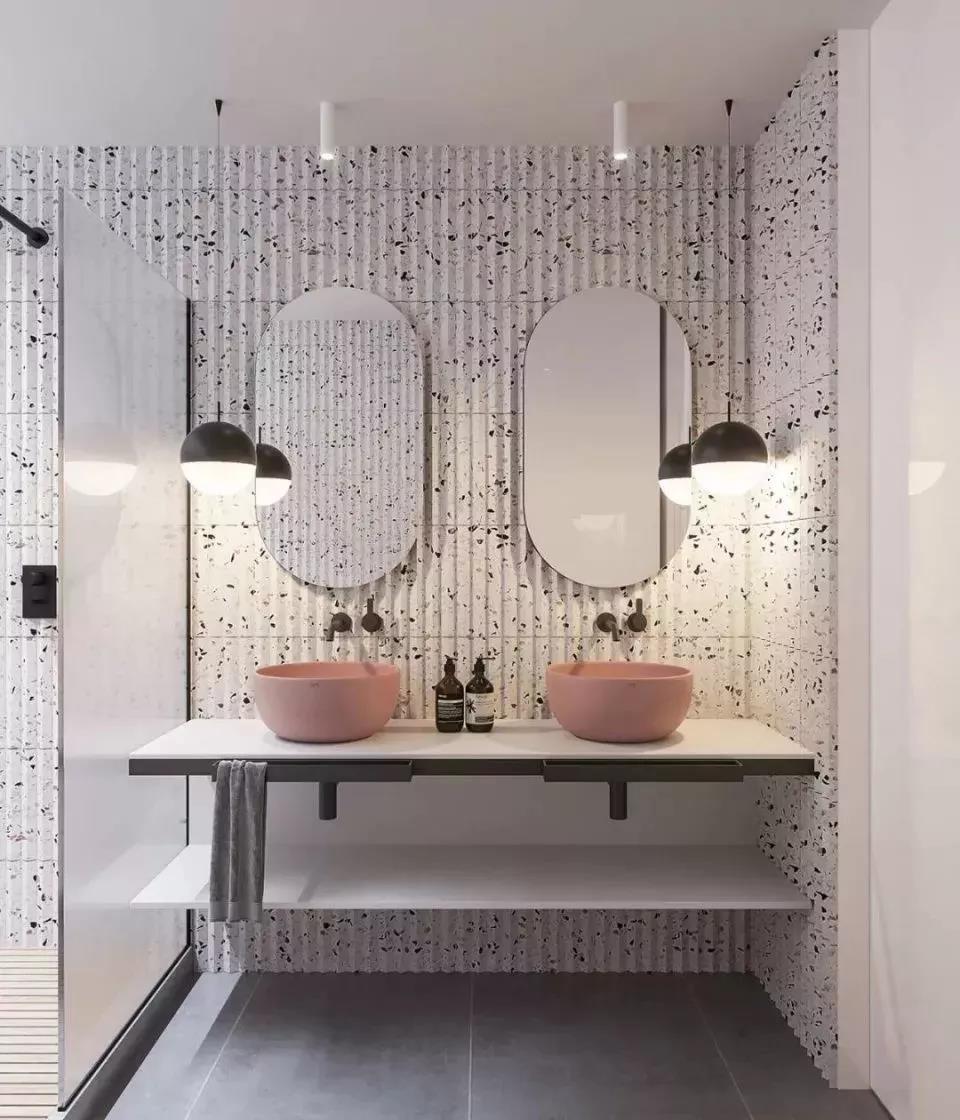 以杂色玻化砖装点的卫生间， 凹凸的墙面肌理感很强， 双洗手台的设计近几年比较流行， 粉嫩的陶瓷带出梦幻气息。