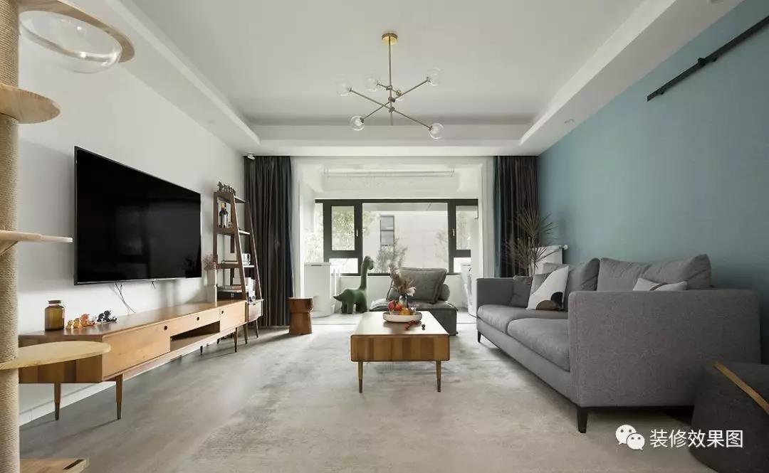 客厅整体以灰白色调为主，搭配原木色的家具，给柔和的空间增添了几分质感。极简的电视背景墙，在复古的电视柜和置物架的衬托下，也别有一番风味。