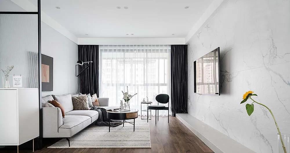 客厅灰白两色构成 整个空间的背景基调 黑色贯穿的家具框架 与深色窗帘的勾勒 强化着空间的立体感与层次性