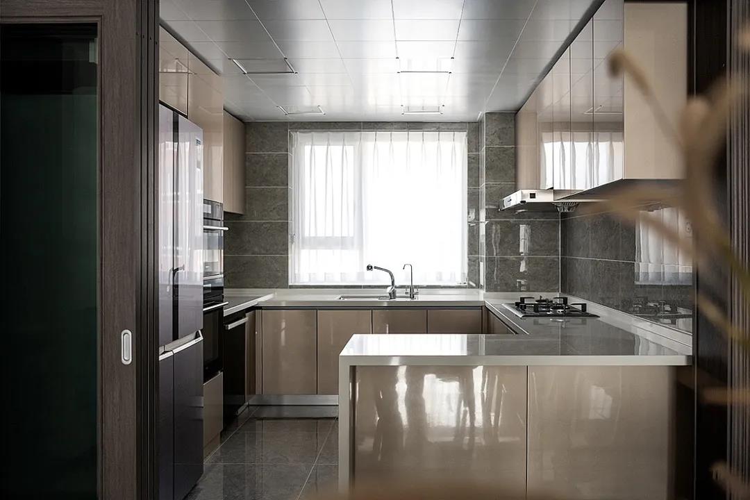 拆掉厨房的一面墙体，打开了厨房餐厅的格局，改造成现在的半开放式的厨房，U型橱柜，让厨房的空间得到合理的利用，灰色瓷砖也为空间颜值加分。